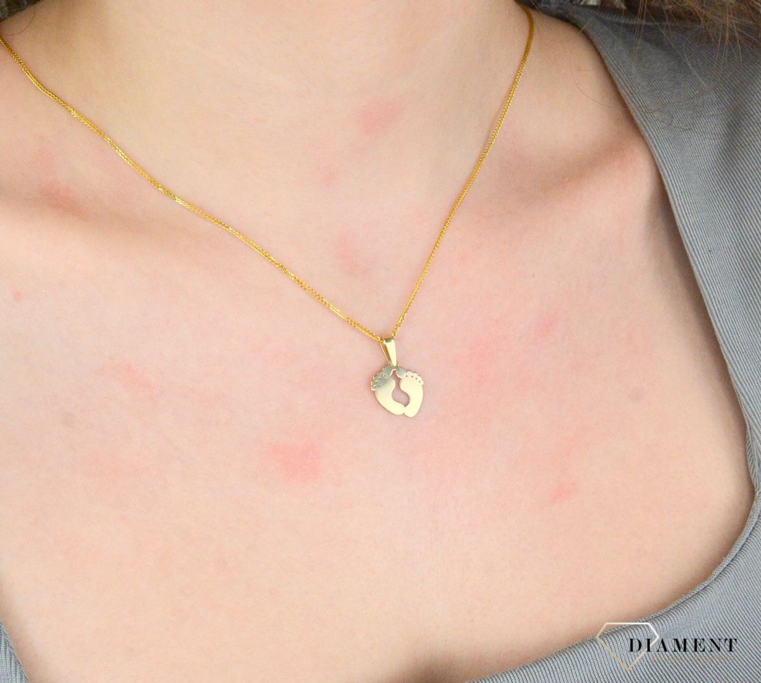 Zawieszka złota damska stopy stópki próba 375, ZA 5602 375  Piękny, złoty wisiorek o ciekawym wzorze wykonany z żółtego złota. Zawieszka w formie stópek. Wisiorek został wykonany z wysokiej jakości złota próby 375.1.jpg